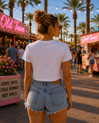 Back view of woman wearing white Western Babe crop tee with denim shorts