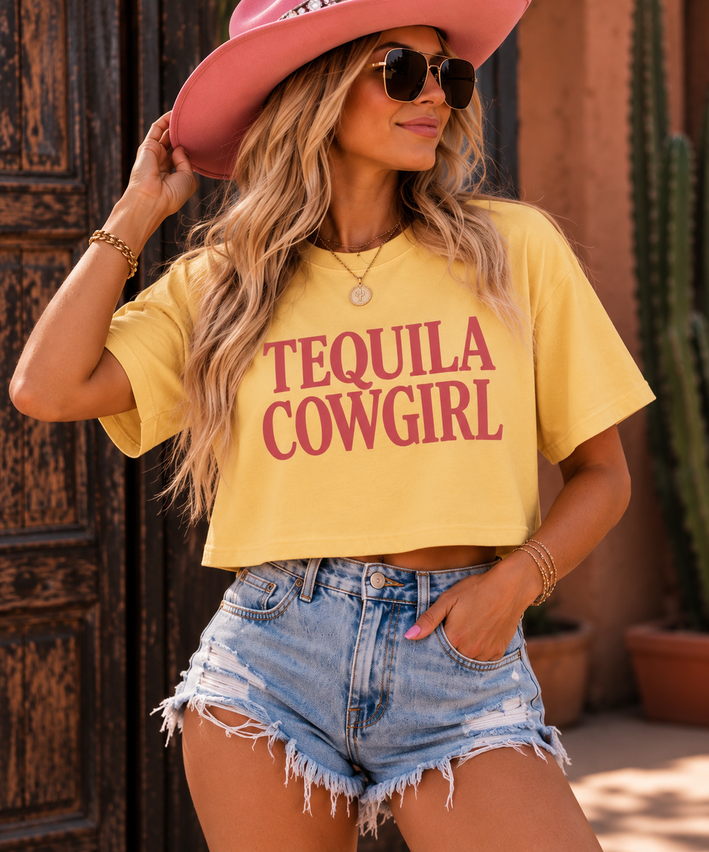 Woman wearing the Tequila Cowgirl boxy tee with denim shorts and a pink cowboy hat