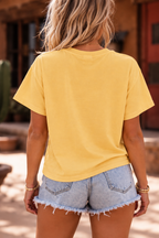 Back view of woman wearing the Tequila Cowgirl boxy tee with denim shorts