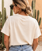 Blonde woman wearing the Howdy Darlin’ crop tee from the back with denim shorts