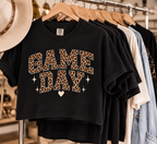 Black Game Day crop tee displayed on a wooden hanger