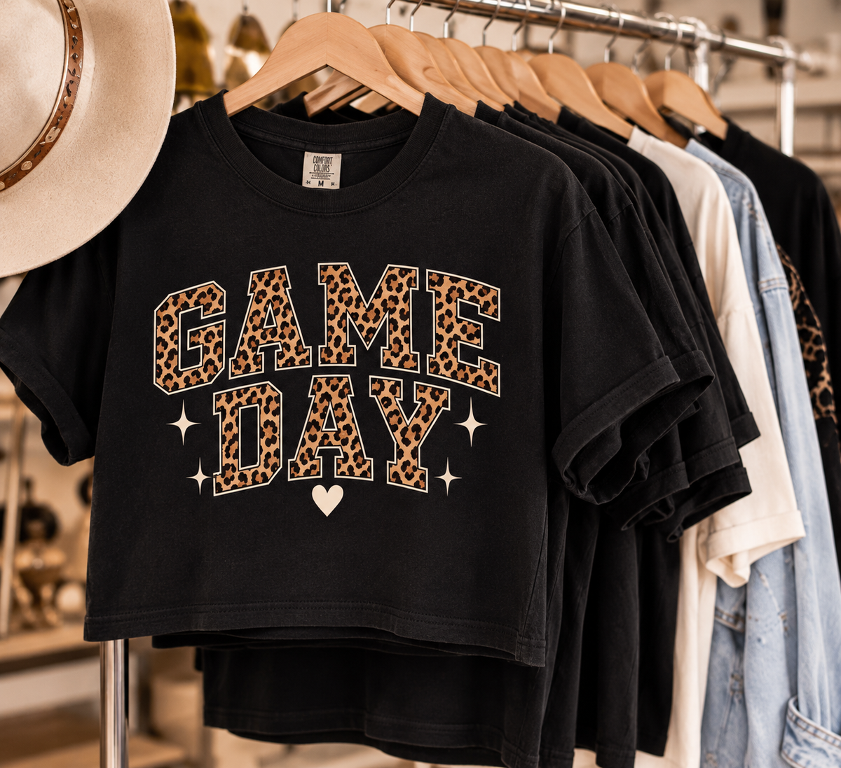 Black Game Day crop tee displayed on a wooden hanger