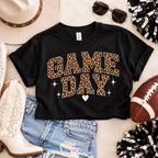 Black Game Day crop tee styled in a football-inspired flat lay